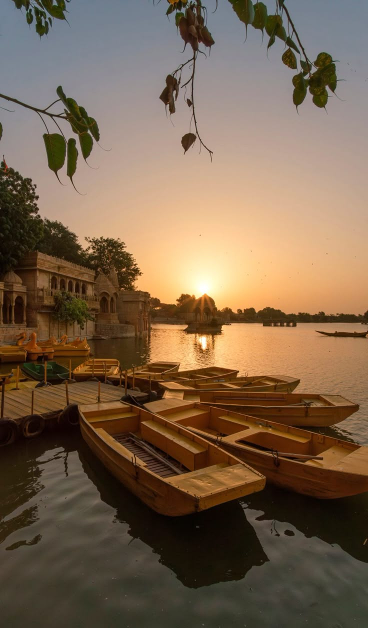 Gadisar Lake in Jaisalmer with historic temples and boats at sunset